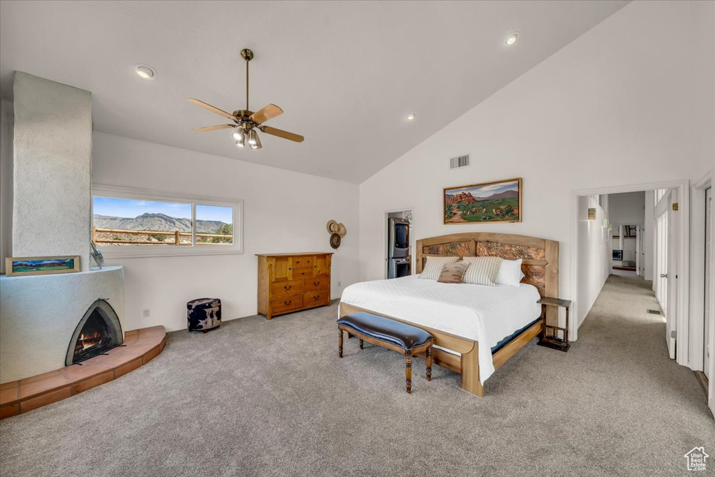 Bedroom featuring high vaulted ceiling, light colored carpet, and ceiling fan