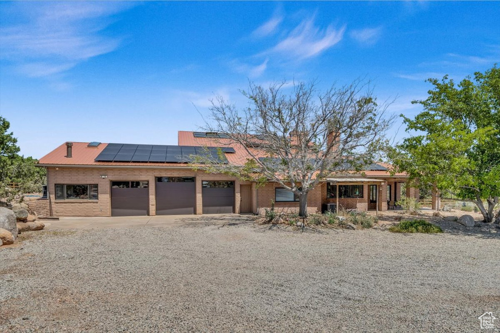 View of front of house featuring solar panels and a garage