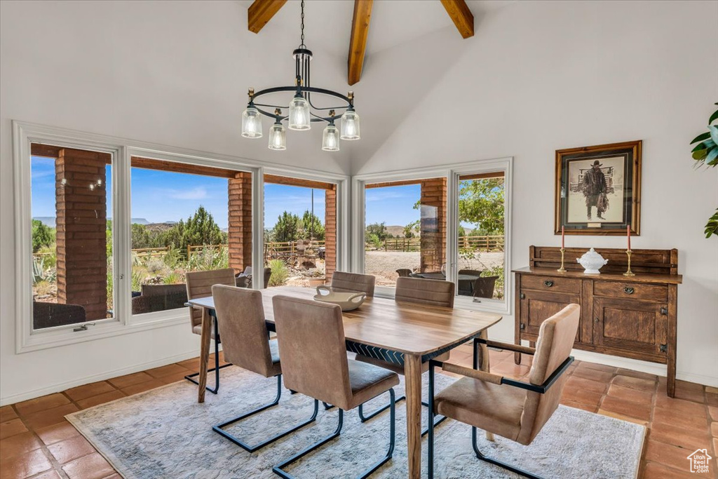 Tiled dining area with beamed ceiling, high vaulted ceiling, and a chandelier