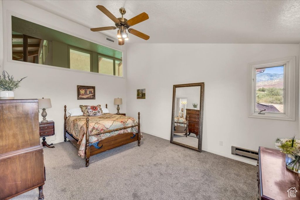 Bedroom featuring carpet, lofted ceiling, a baseboard heating unit, and ceiling fan