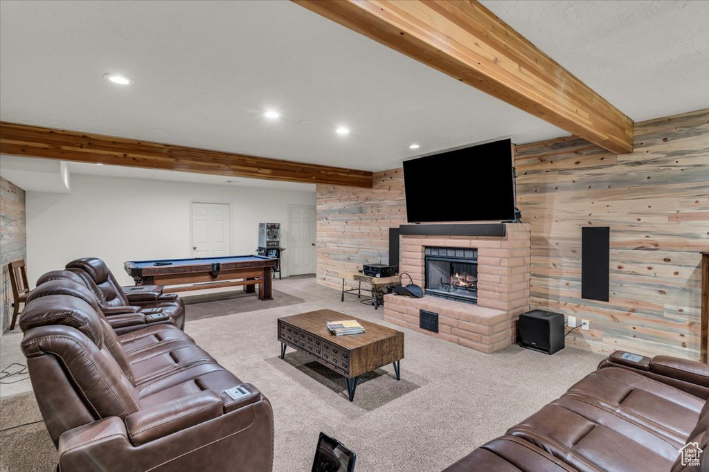 Carpeted living room with a brick fireplace, brick wall, wood walls, beamed ceiling, and pool table