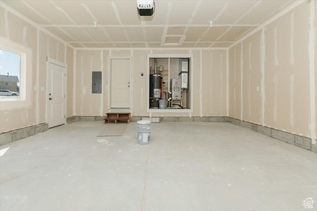 Interior space featuring gas water heater, electric panel, and concrete flooring