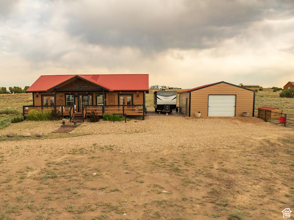 View of yard with a garage, an outdoor structure, and a porch