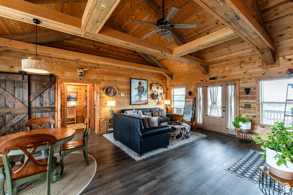 Living room featuring dark hardwood / wood-style flooring, wooden walls, vaulted ceiling with beams, and wood ceiling