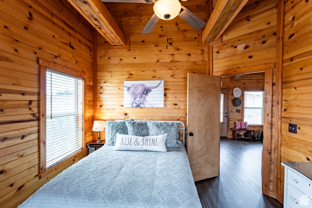 Bedroom with wood walls, dark hardwood / wood-style flooring, and beamed ceiling