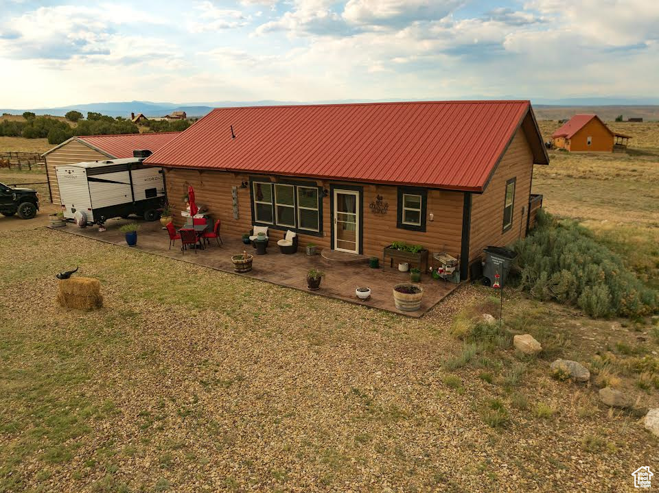 Back of house with a patio area and an outdoor structure