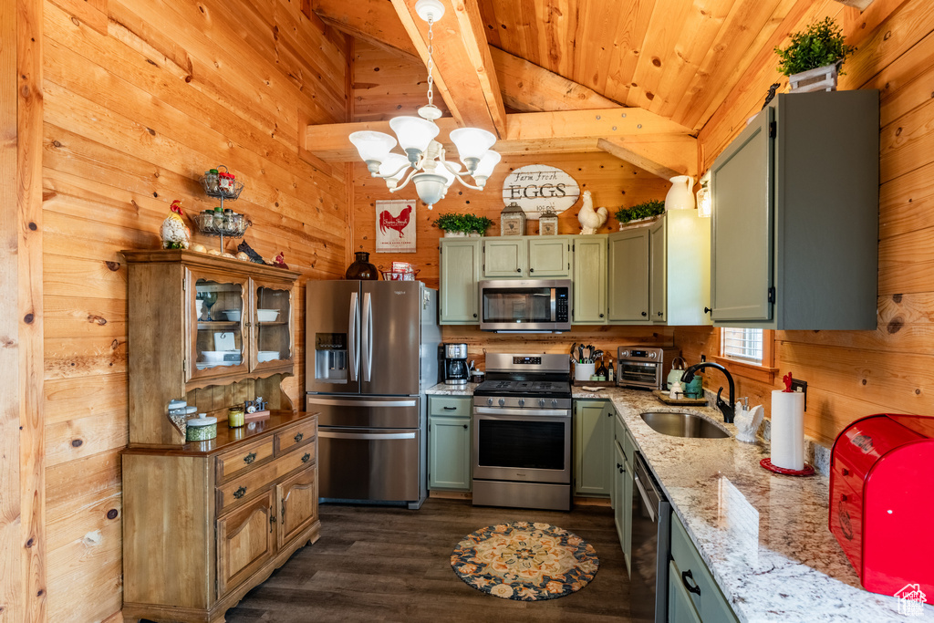 Kitchen featuring lofted ceiling with beams, wooden walls, stainless steel appliances, and dark wood-type flooring