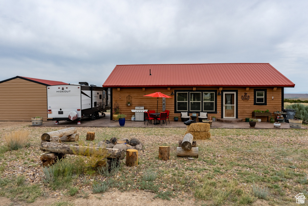 Back of property with an outbuilding and a patio