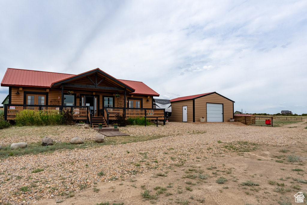 Cabin with an outbuilding, a garage, and a porch