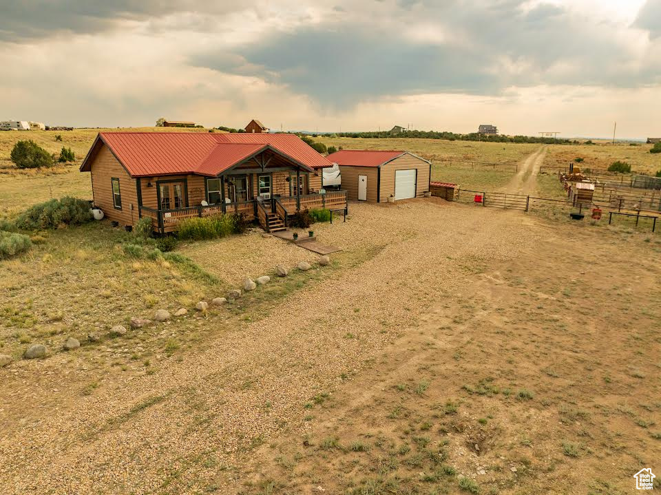 View of front of property with an outbuilding, a rural view, and a garage