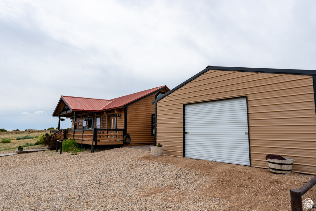 View of front of home with a garage and an outdoor structure