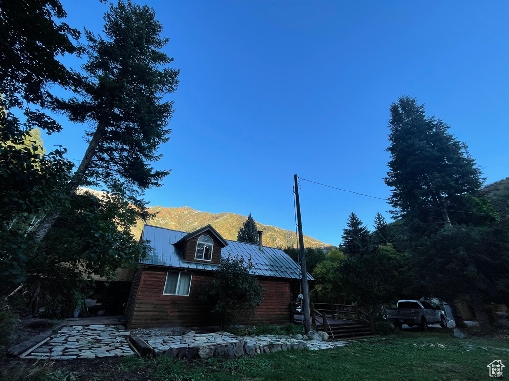 View of side of home with a mountain view