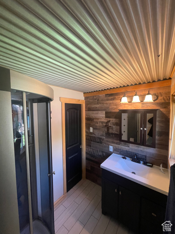 Bathroom featuring wood walls, vanity, and hardwood / wood-style flooring