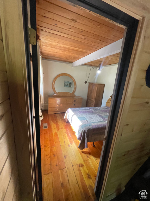 Bedroom with wood ceiling and light wood-type flooring