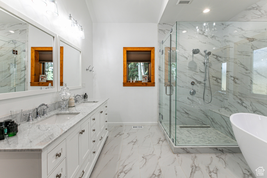 Bathroom featuring plus walk in shower, dual vanity, and tile patterned flooring