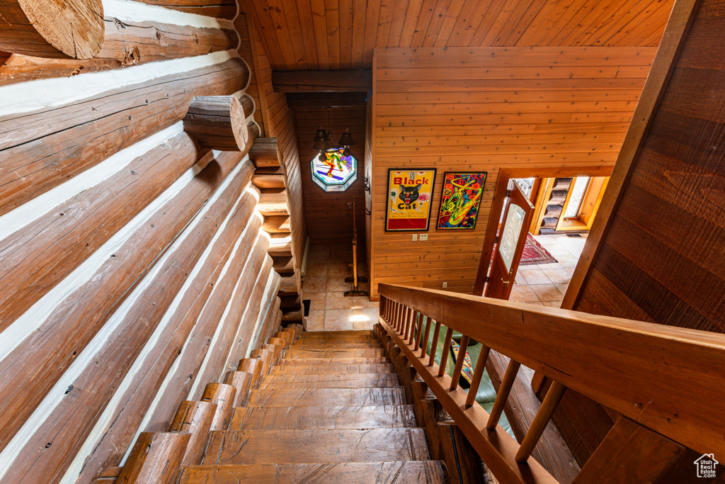 Stairs featuring wooden walls and wood ceiling