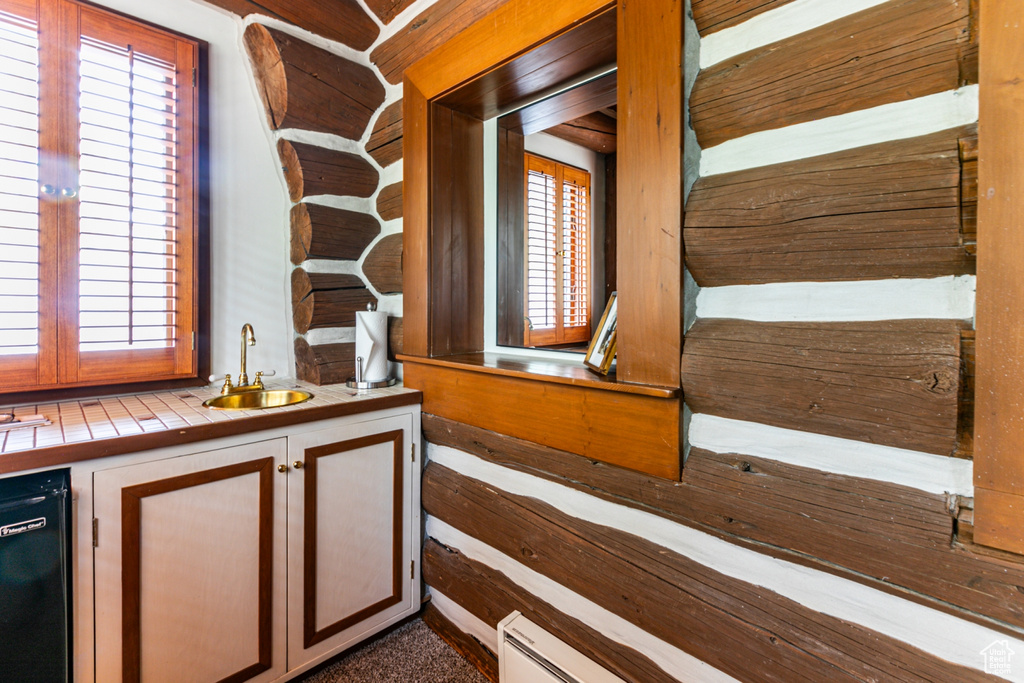 Interior space with tile counters, sink, dishwasher, and a healthy amount of sunlight