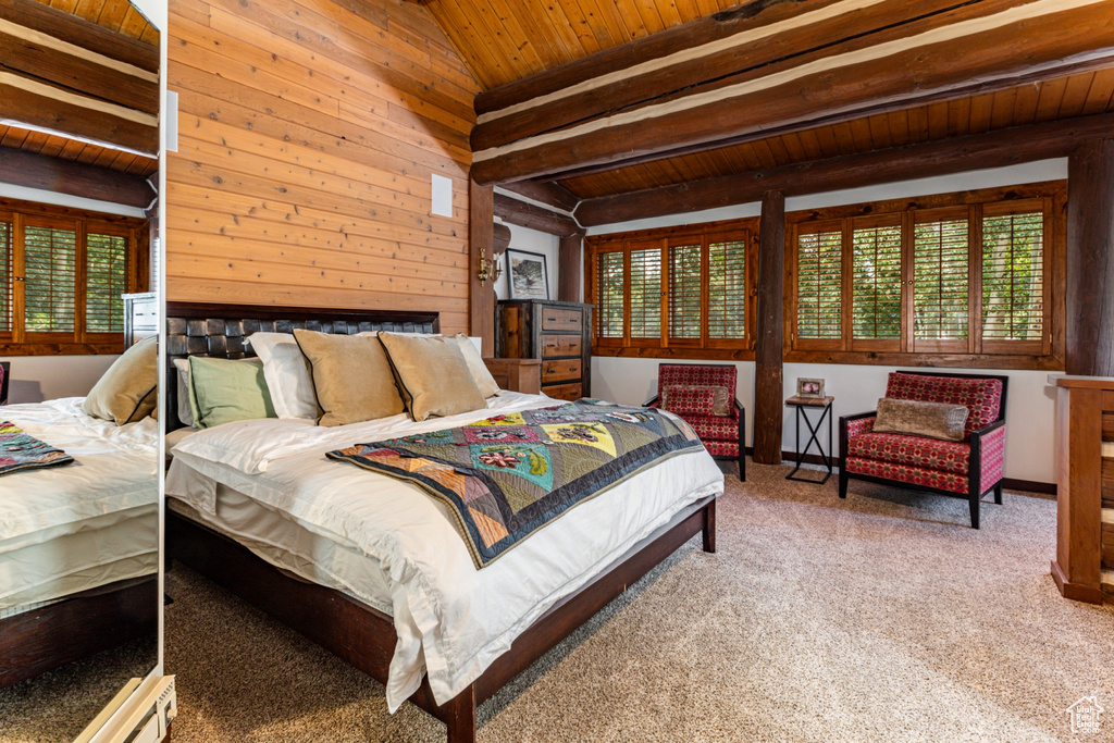 Carpeted bedroom featuring wood walls, vaulted ceiling with beams, and wooden ceiling