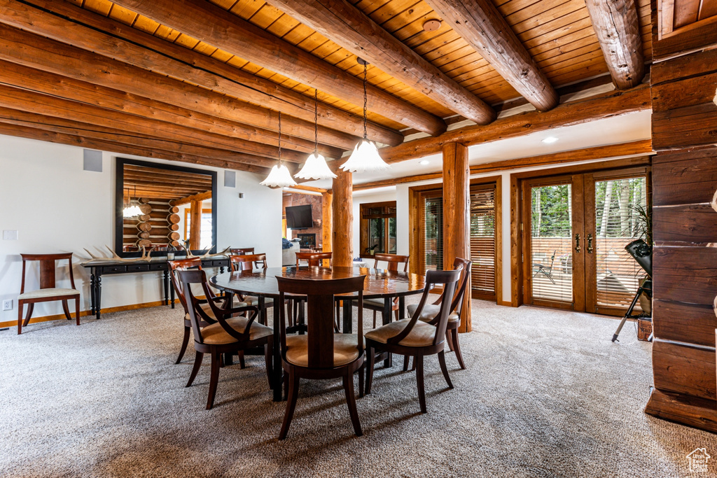 Carpeted dining space with log walls, french doors, beamed ceiling, and wood ceiling