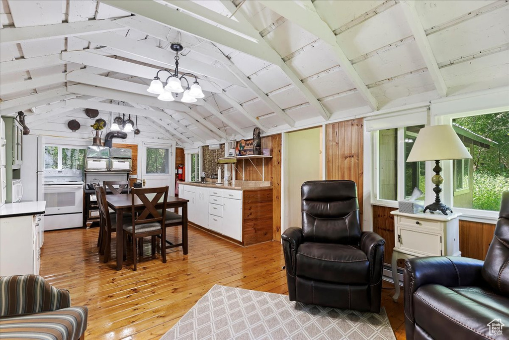 Living room featuring plenty of natural light, a chandelier, light hardwood / wood-style flooring, and vaulted ceiling