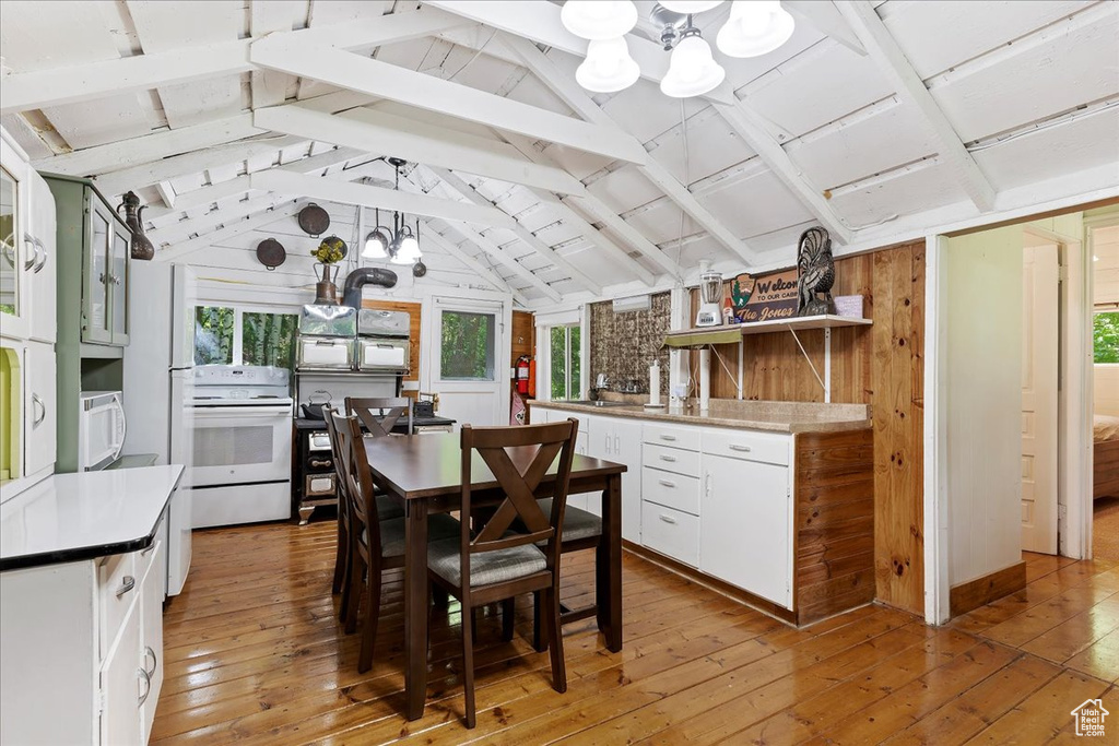 Interior space featuring light hardwood / wood-style floors, lofted ceiling with beams, white cabinets, and white appliances