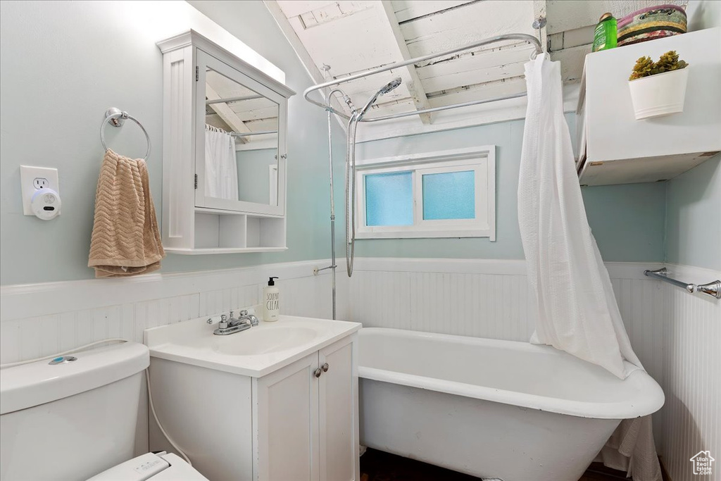 Full bathroom featuring shower / tub combo, toilet, and vanity