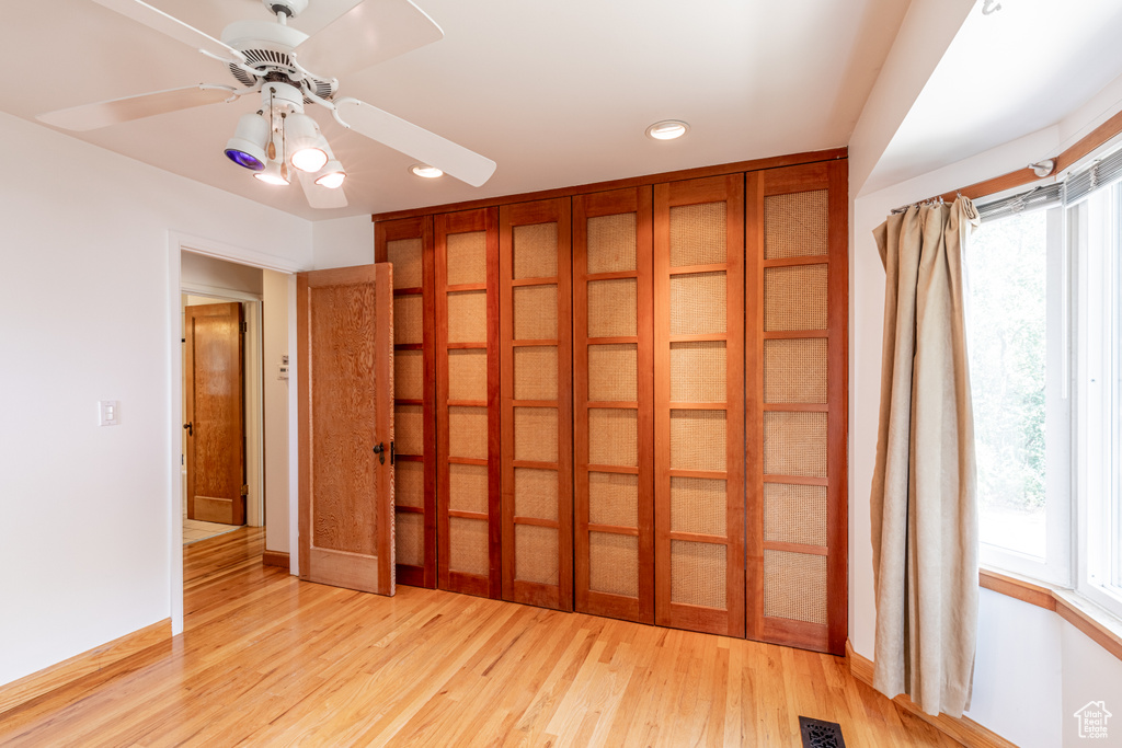 Spare room with ceiling fan, light hardwood / wood-style flooring, and plenty of natural light