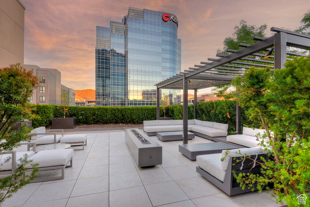 Patio terrace at dusk featuring a pergola and outdoor lounge area