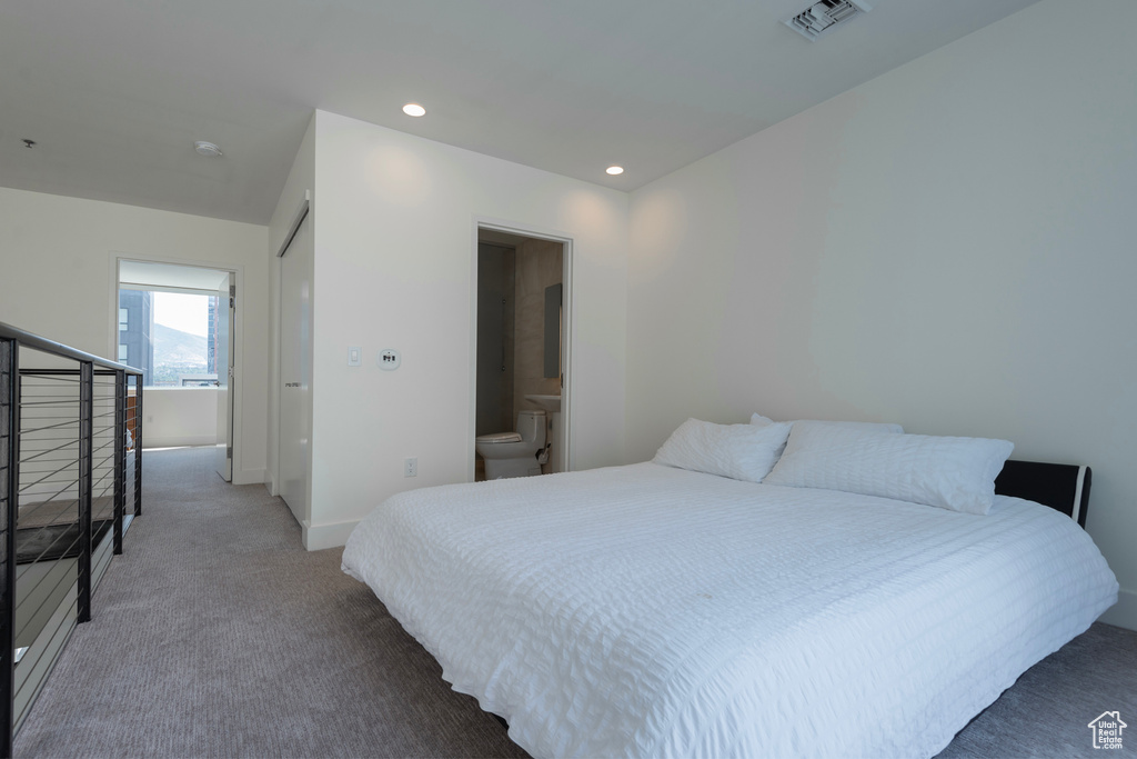 Bedroom featuring connected bathroom and carpet floors