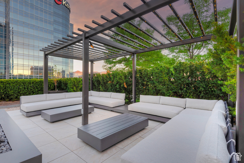 Patio terrace at dusk featuring a pergola and an outdoor hangout area