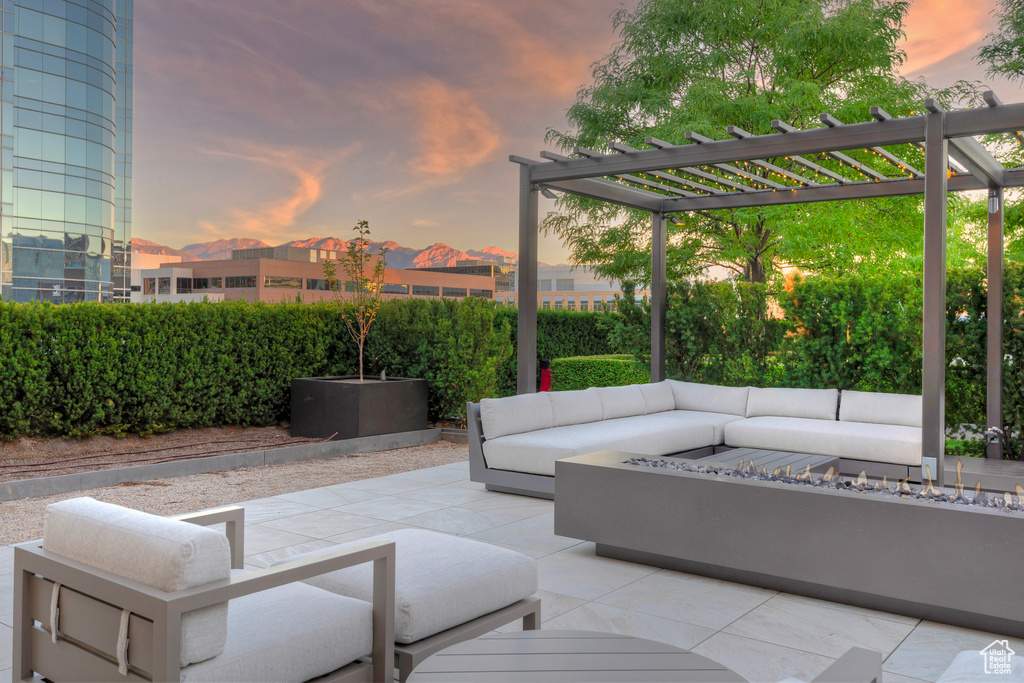 Patio terrace at dusk with an outdoor living space with a fire pit