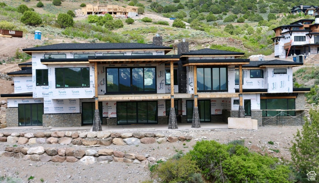Back of property featuring stone siding