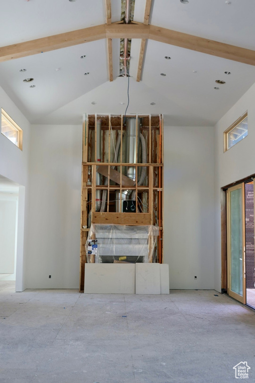Unfurnished living room featuring high vaulted ceiling