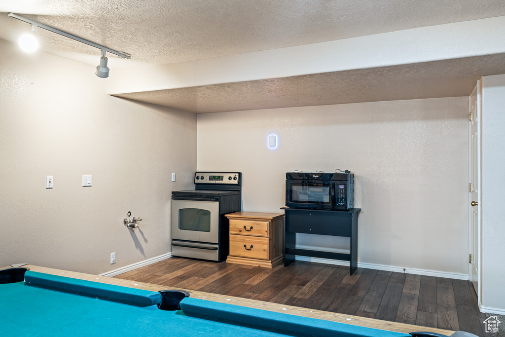 Kitchen with a textured ceiling, dark hardwood / wood-style floors, rail lighting, billiards, and electric range