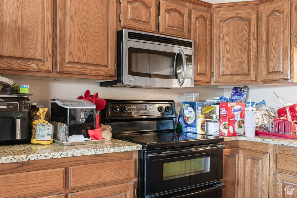 Kitchen with light stone counters and electric range