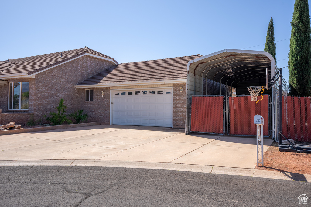 View of front of home with a garage and a carport