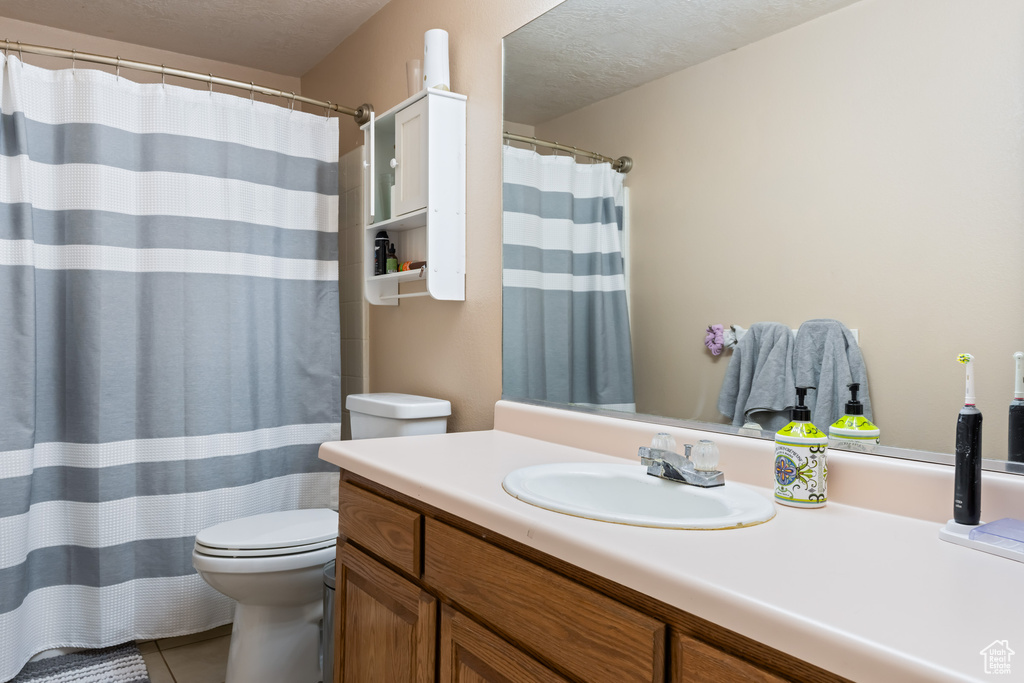 Bathroom with tile patterned floors, vanity, and toilet