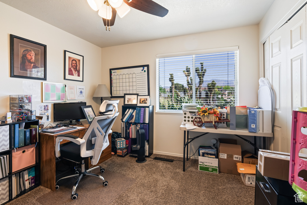 Carpeted home office with ceiling fan