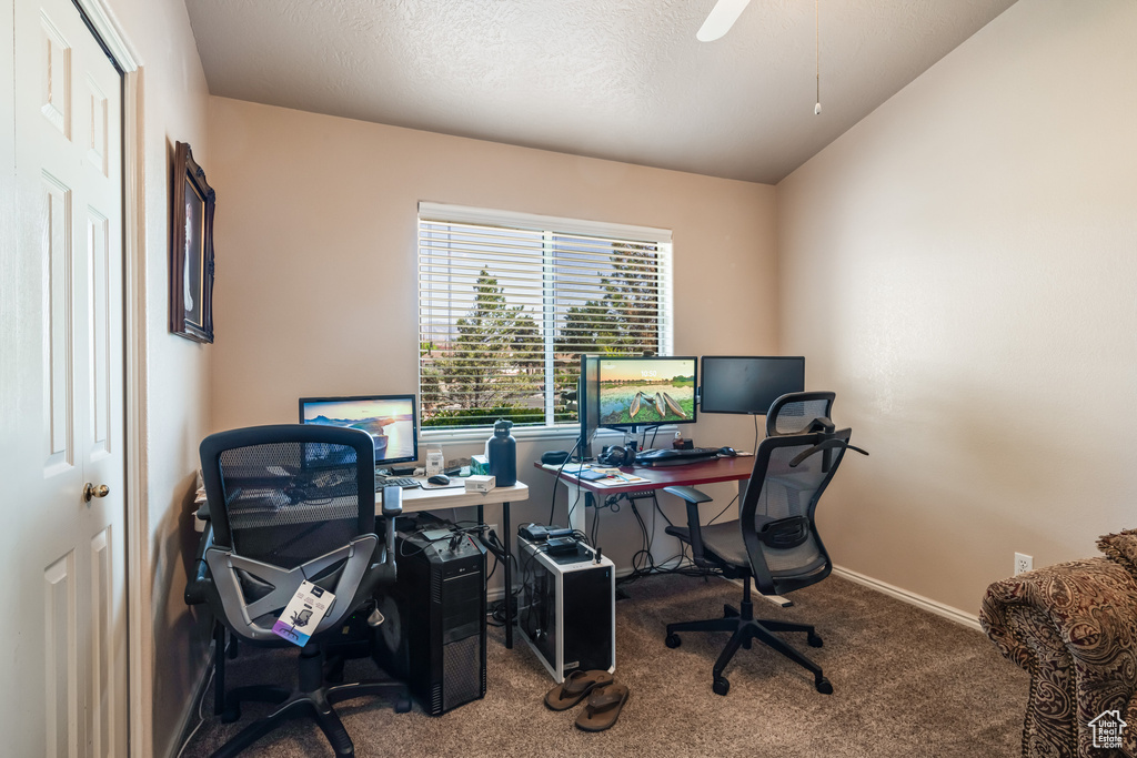 Home office with lofted ceiling, carpet, and ceiling fan