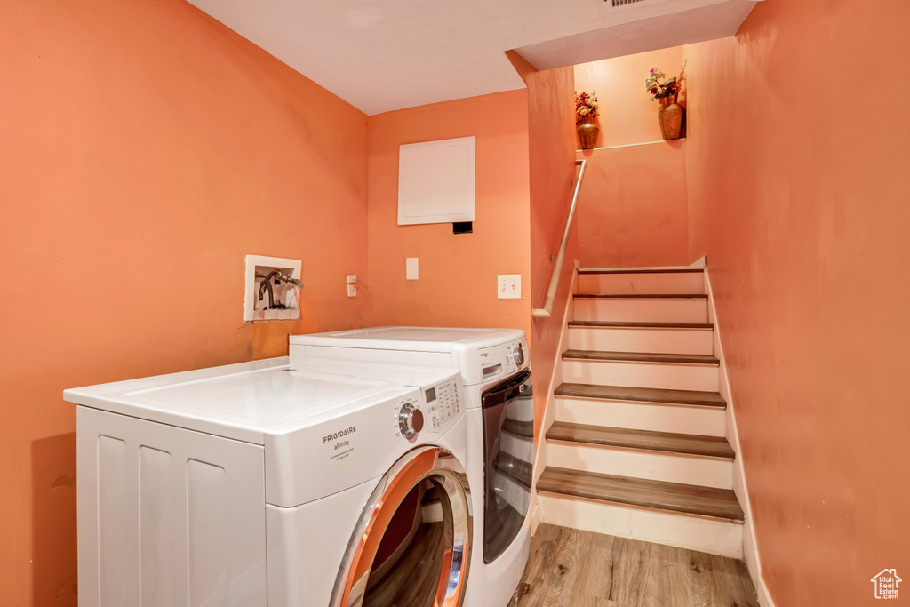 Washroom featuring light hardwood / wood-style flooring and washing machine and clothes dryer