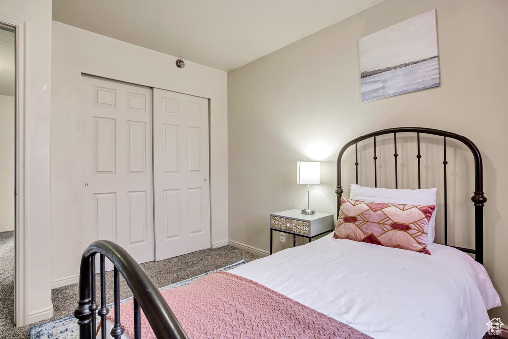 Carpeted bedroom featuring a closet