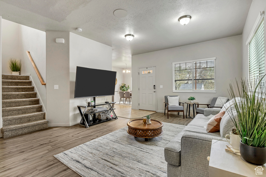 Living room featuring a textured ceiling and light hardwood / wood-style floors