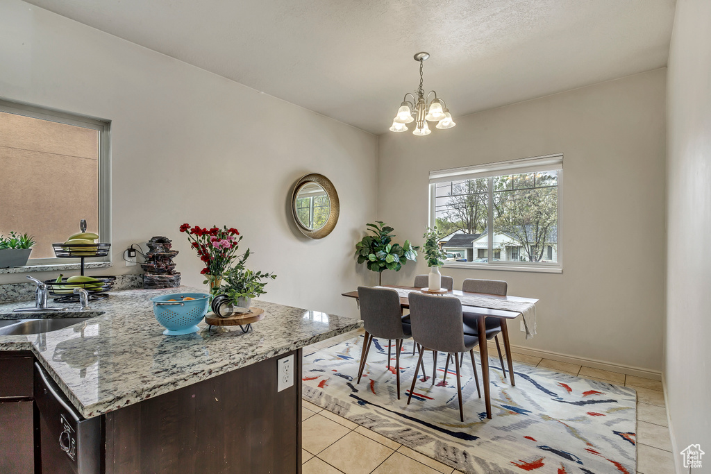 Dining room featuring a notable chandelier, sink, and light tile patterned floors