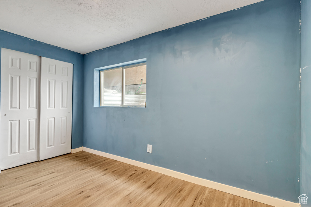 Unfurnished bedroom with light wood-type flooring and a closet