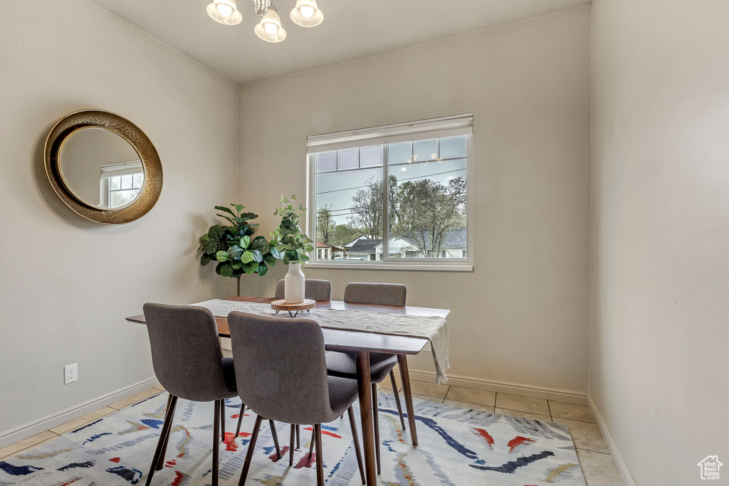 Dining space featuring light tile patterned floors and an inviting chandelier