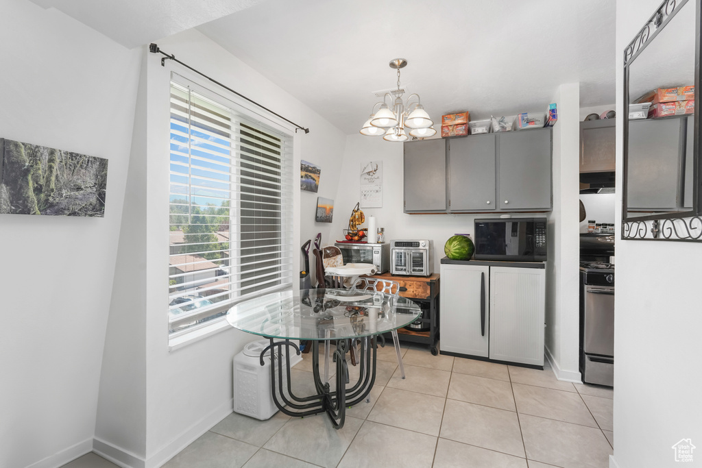 Dining space featuring light tile patterned floors and an inviting chandelier