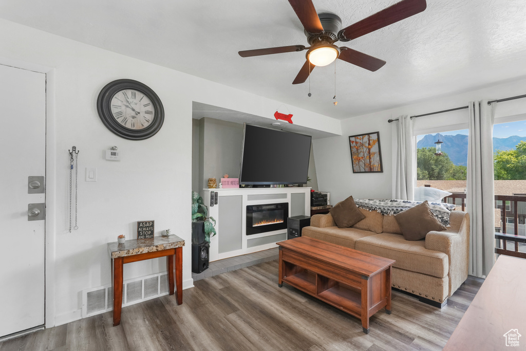 Living room with ceiling fan and hardwood / wood-style flooring