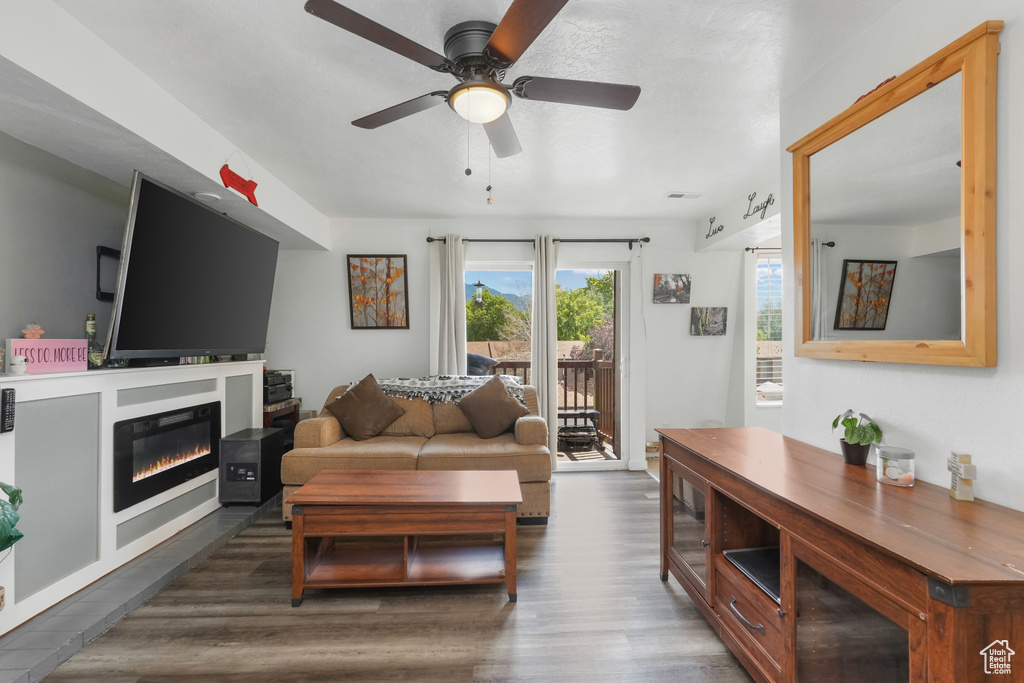 Living room with ceiling fan and hardwood / wood-style flooring