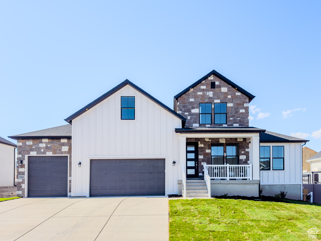 View of front of house with a porch and a front yard