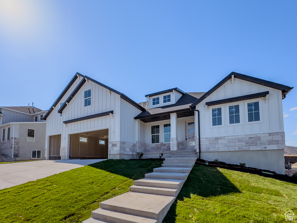 View of front of house featuring a front yard and a garage